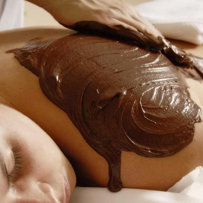 Chocolate body scrub being applied to a person's back