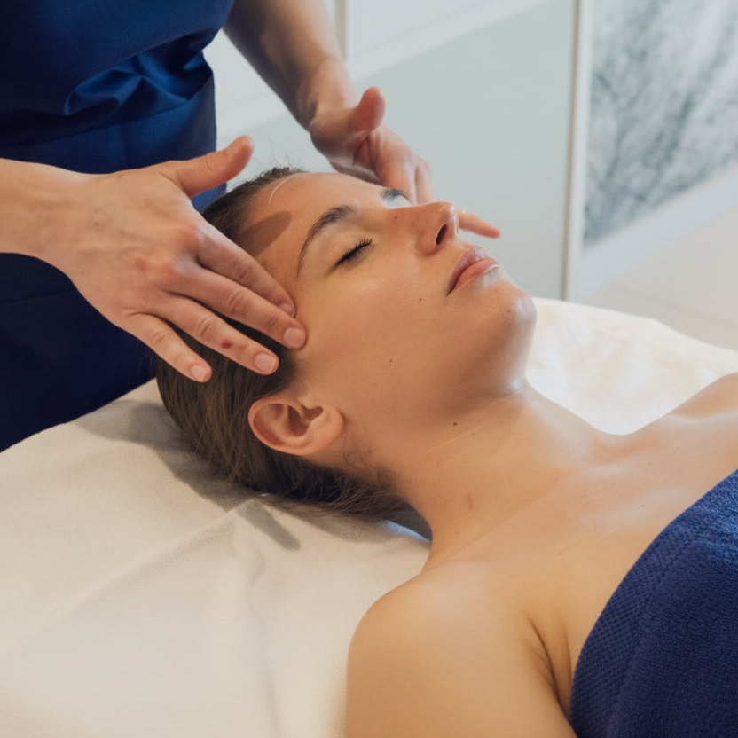 Person receiving a facial massage in a clinical setting