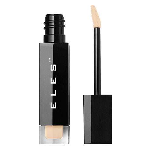 A bottle of liquid concealer with its applicator next to it, the concealer is a light beige color, and the packaging is black with the brand name 'ELE'S' on it.