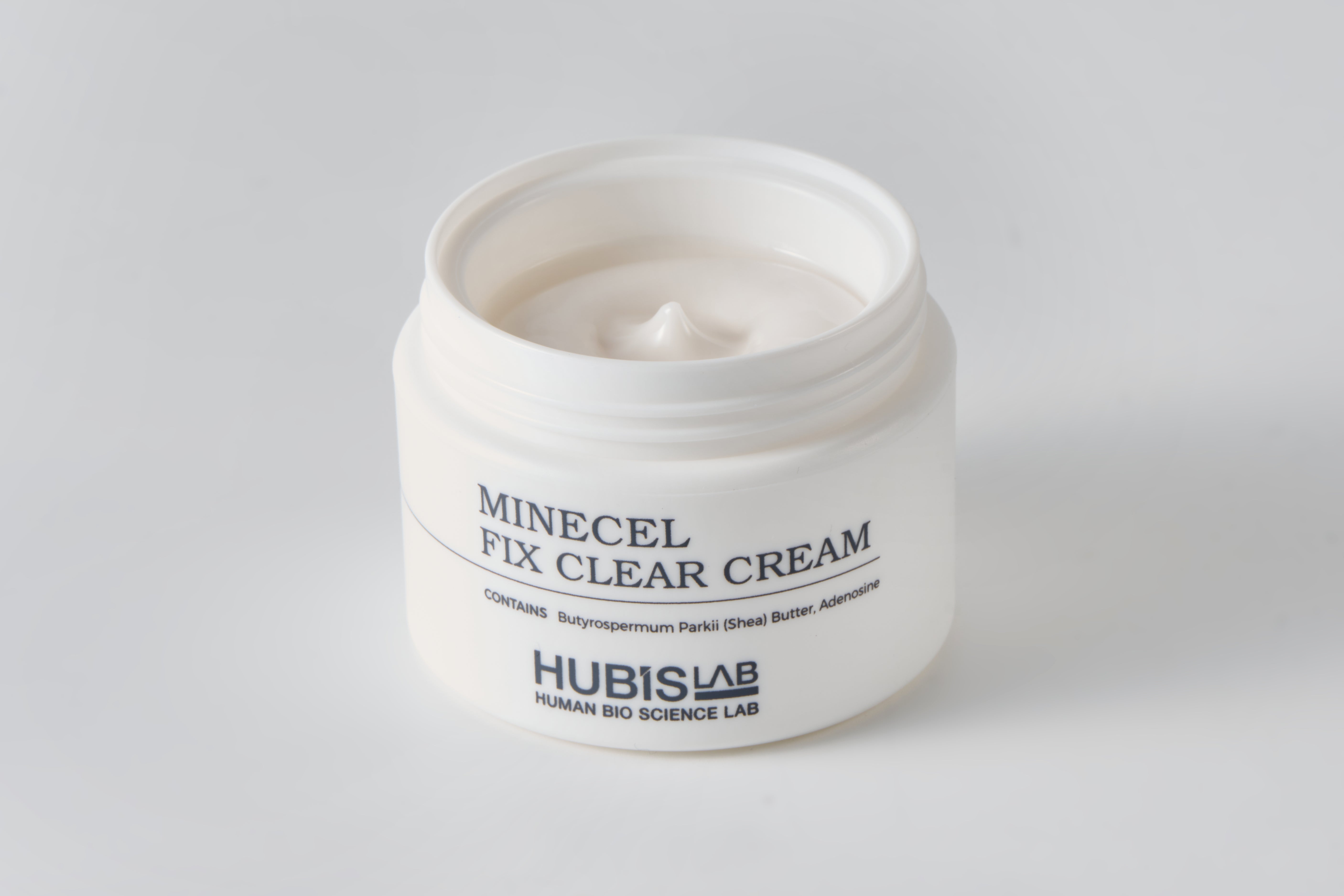 Jar of Minecel Fix Clear Cream from Hubislab on a gray background