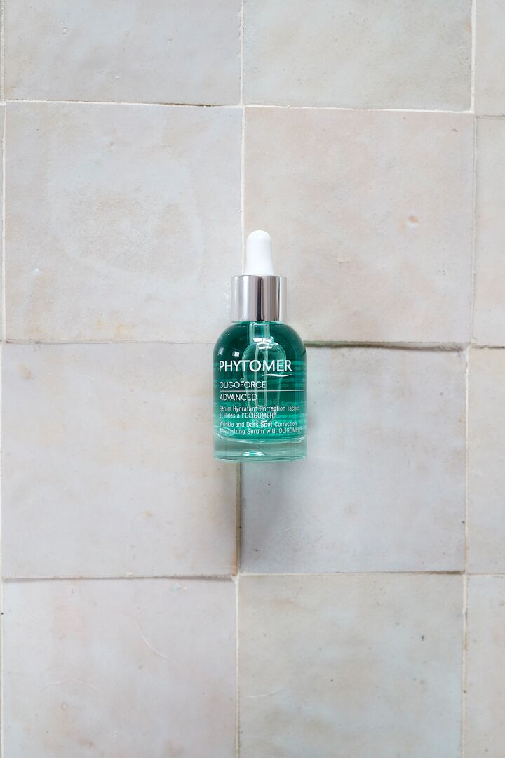 Bottle of Phytomer serum on a tiled wall