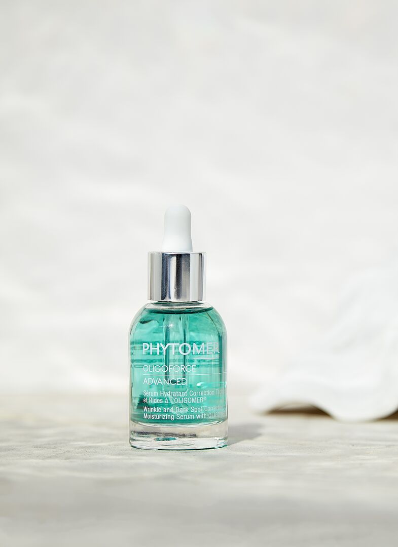 Skincare bottle with a white cap on a light background