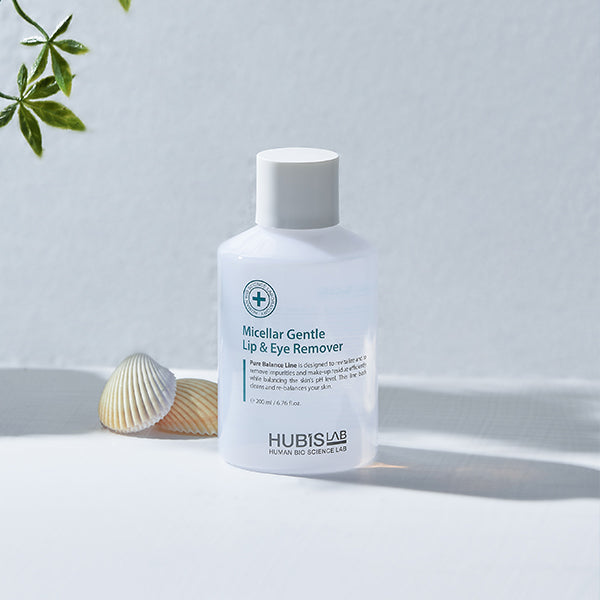 Bottle of Hubislab Micellar Gentle Lip & Eye Remover on a light background with a shell and plant.
