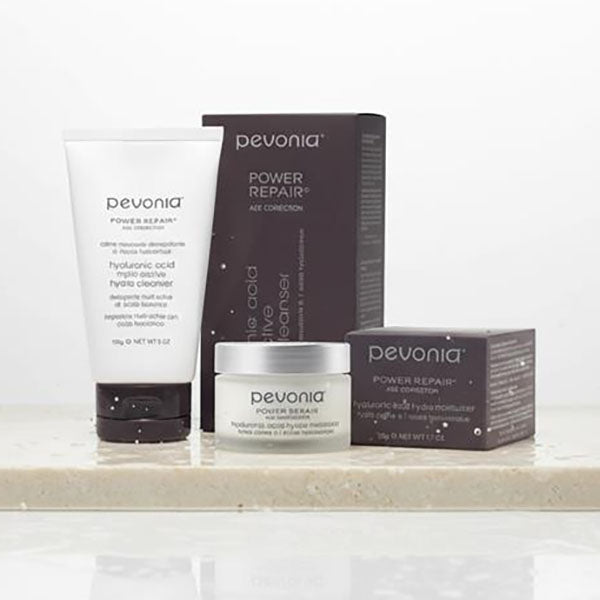 Pevonia skincare products including a tube, jar, and boxes on a light surface.