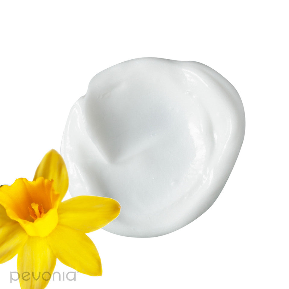 A smear of of Pevonia Power Repair-Hydrating Cleanser, designed for cleansing the skin, White cream with a yellow flower indicating the ingredients on a white background, featuring the Pevonia brand.