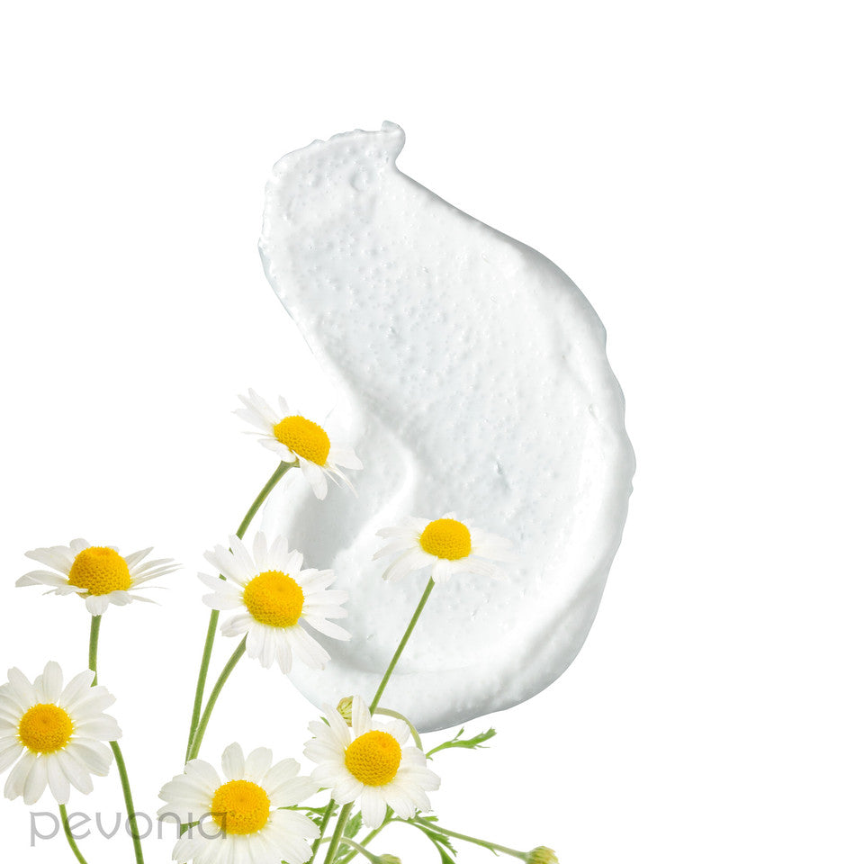Pevonia Silky Skin body scrub ingredients showing body scrub cream smear with daisies on a white background