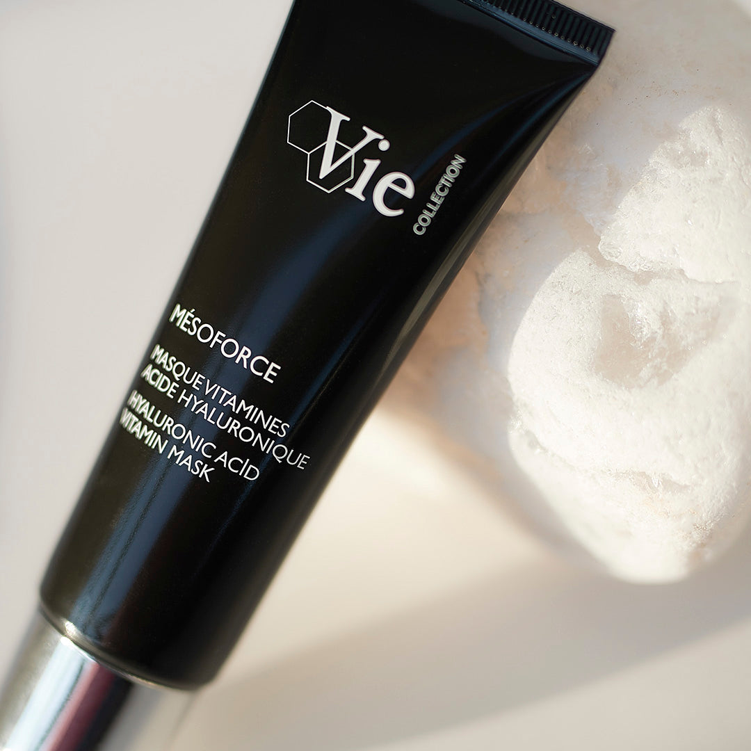 Black skincare product tube with white text on a light background