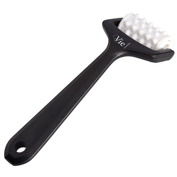 A black handheld skincare roller with white micro-needles