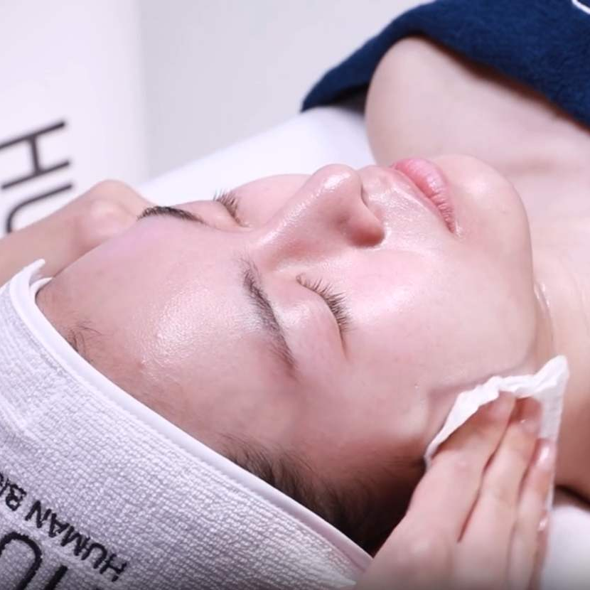 Person receiving a facial treatment with UBIIS branding visible.