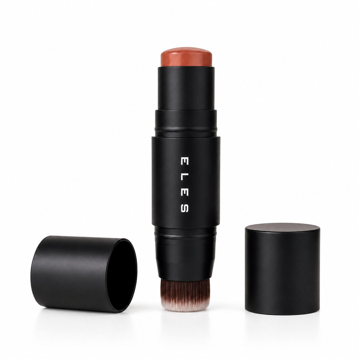 ELES Cheek & Lip Cream Stick with Brush with a black cylindrical body, a warm terracotta-colored cosmetic stick top, and a dual-ended brush bristle base. The main stick stands upright in the center, with its black cap lying on its side to the left and another black cap standing to the right, all on a clean white background.