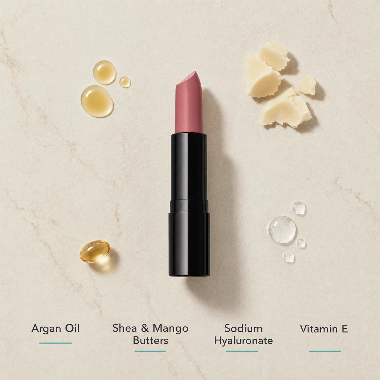 ELES Essence de Nude Lipstick ingredient flatlay featuring argan oil, shea and mango butters, sodium hyaluronate and vitamin E on a warm limestone surface