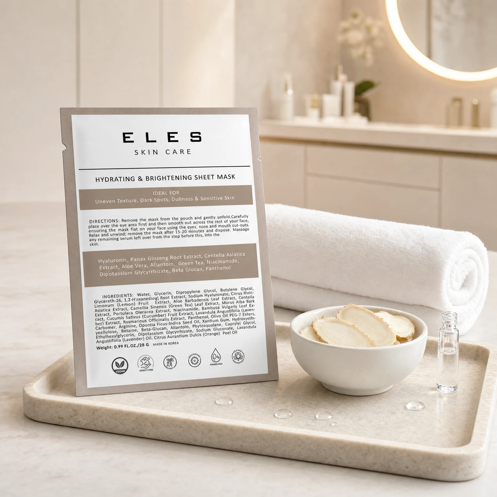 ELES Hydrating and Brightening Sheet Mask warm taupe foil sachet on a stone tray with ginseng root slices and a hyaluronate vial on a marble clinic bench inside a premium skin clinic treatment room