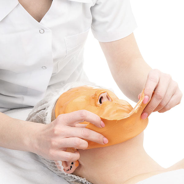 Person holding a silicone mask shaped like a duck over their face on a white background