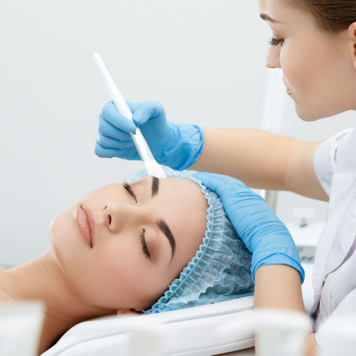 Medicalia Collagen and-Vitamin C Peel being applied with a brush from a glass bowl during a professional peeling treatment