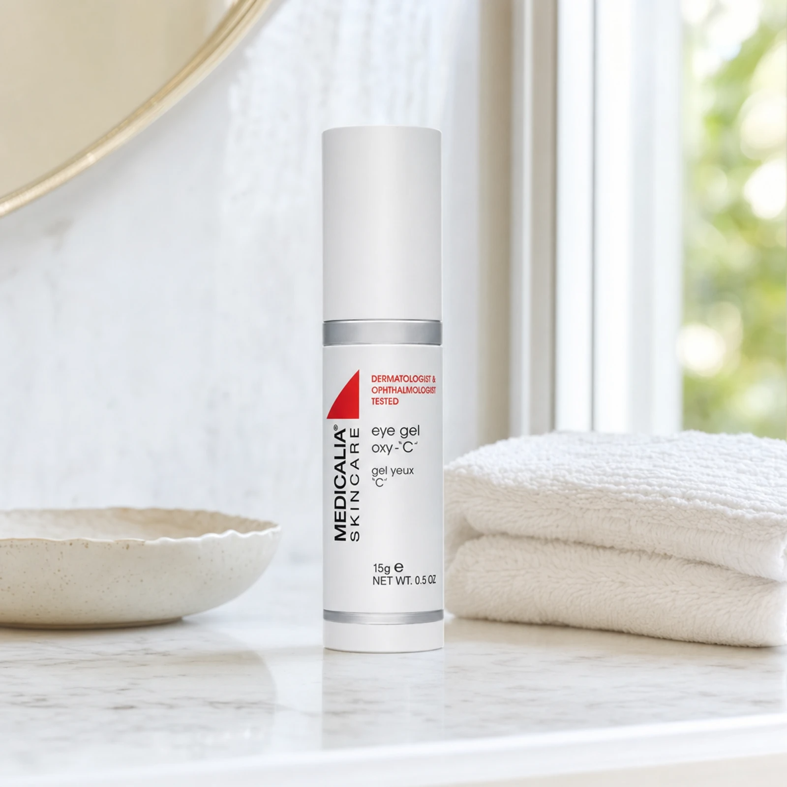 Medicalia Eye Gel Oxy-C 15g on a premium marble bathroom vanity, a refreshing vitamin C eye gel that reduces puffiness, dark circles, and brightens the delicate eye contour