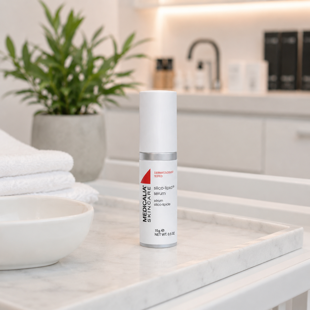 Medicalia Silico-Lipid Serum displayed on a marble clinic benchtop with folded towels, treatment bowl and soft neutral clinic background.