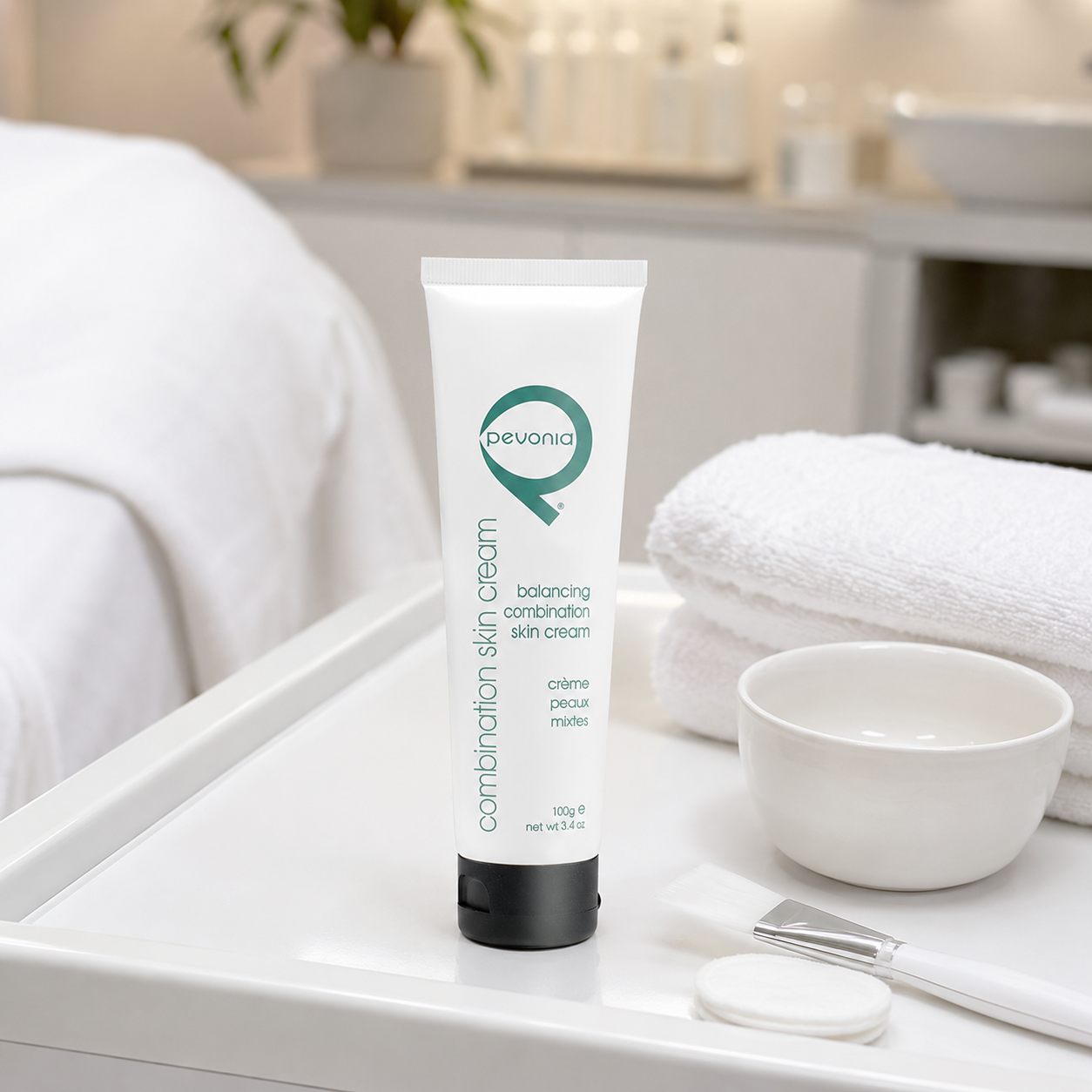 Pevonia Balancing Combination Skin Cream 100g tube displayed on a therapist trolley in a beauty clinic facial treatment room with unbranded treatment accessories.