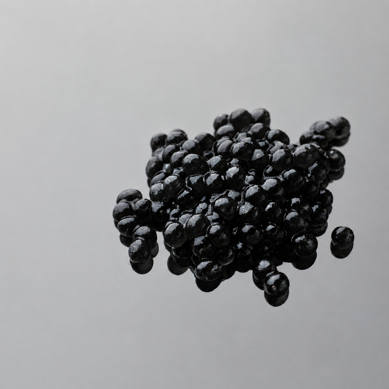 Cluster of black magnetic beads on a light gray background