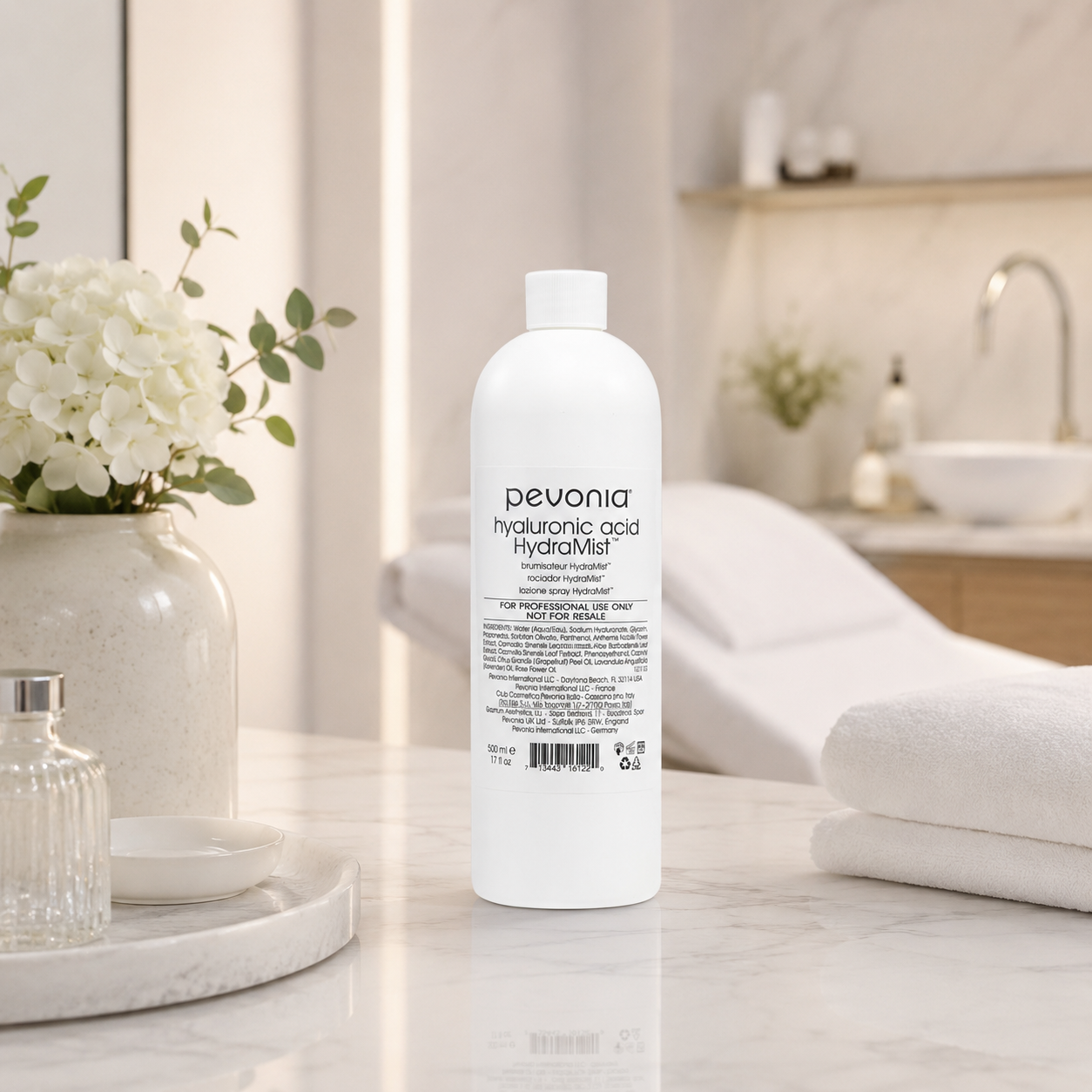 Pevonia Hyaluronic Acid HydraMist 500ml bottle displayed in an upmarket beauty clinic treatment room with unbranded mist