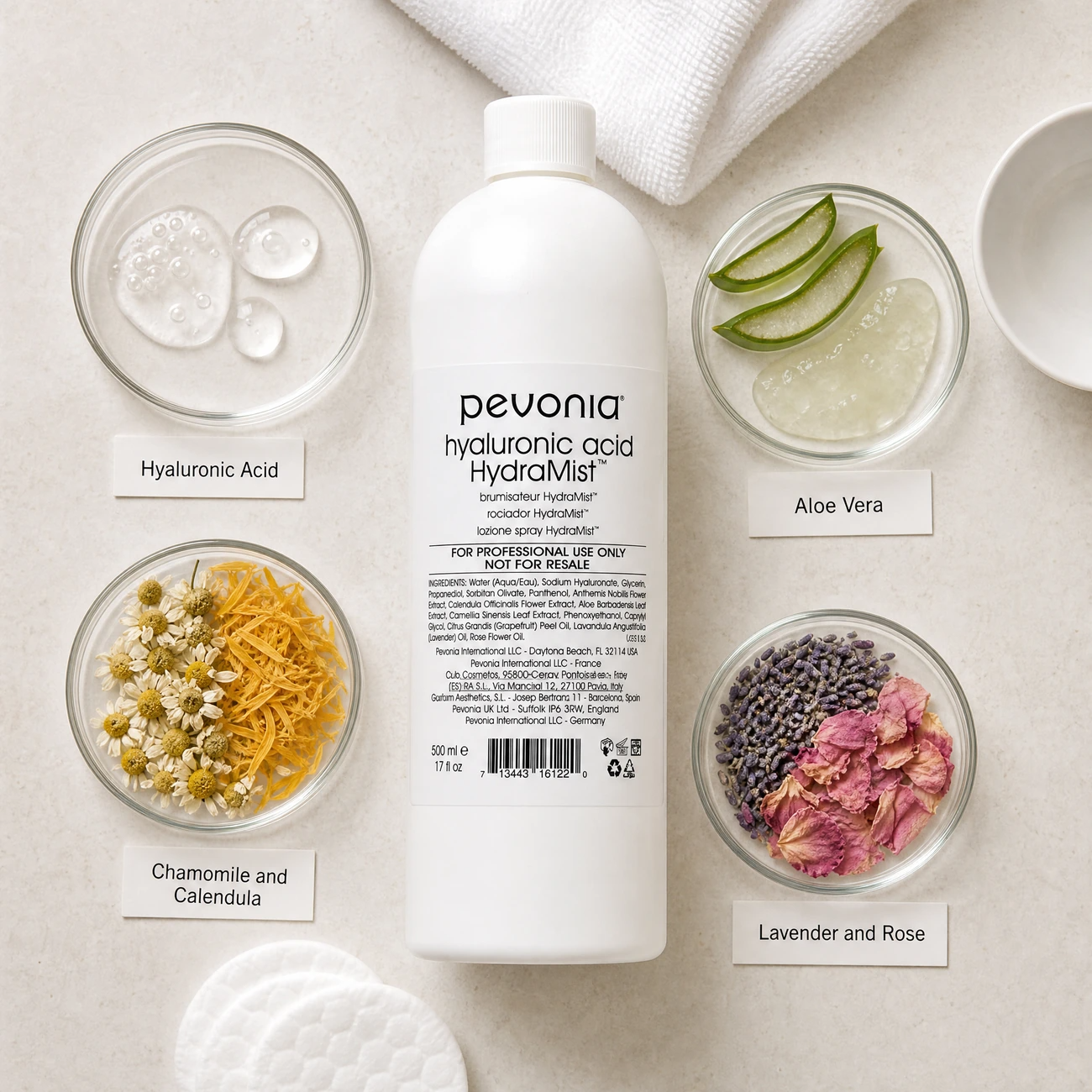 Pevonia Hyaluronic Acid HydraMist 500ml ingredients flatlay with hyaluronic acid, aloe vera, chamomile and calendula, and lavender and rose in clean glass petri dishes for professional B2B education.