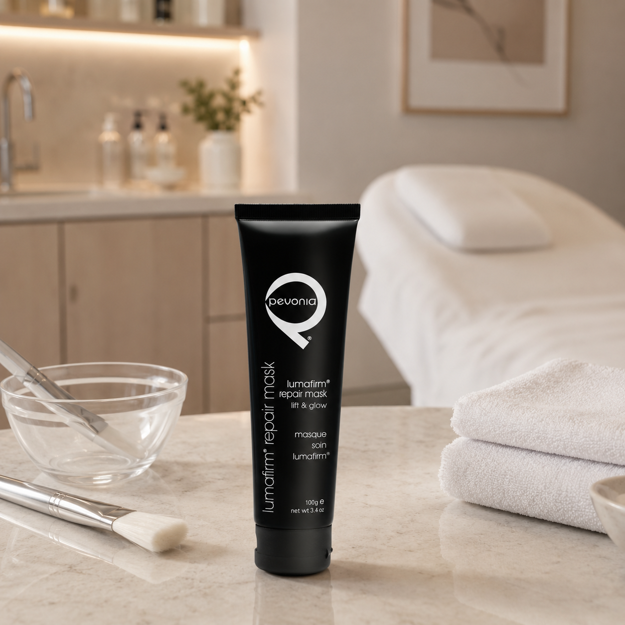 Pevonia Lumafirm Repair Mask Lift and Glow 100g tube displayed in an upmarket beauty clinic treatment room with unbranded mask treatment accessories.