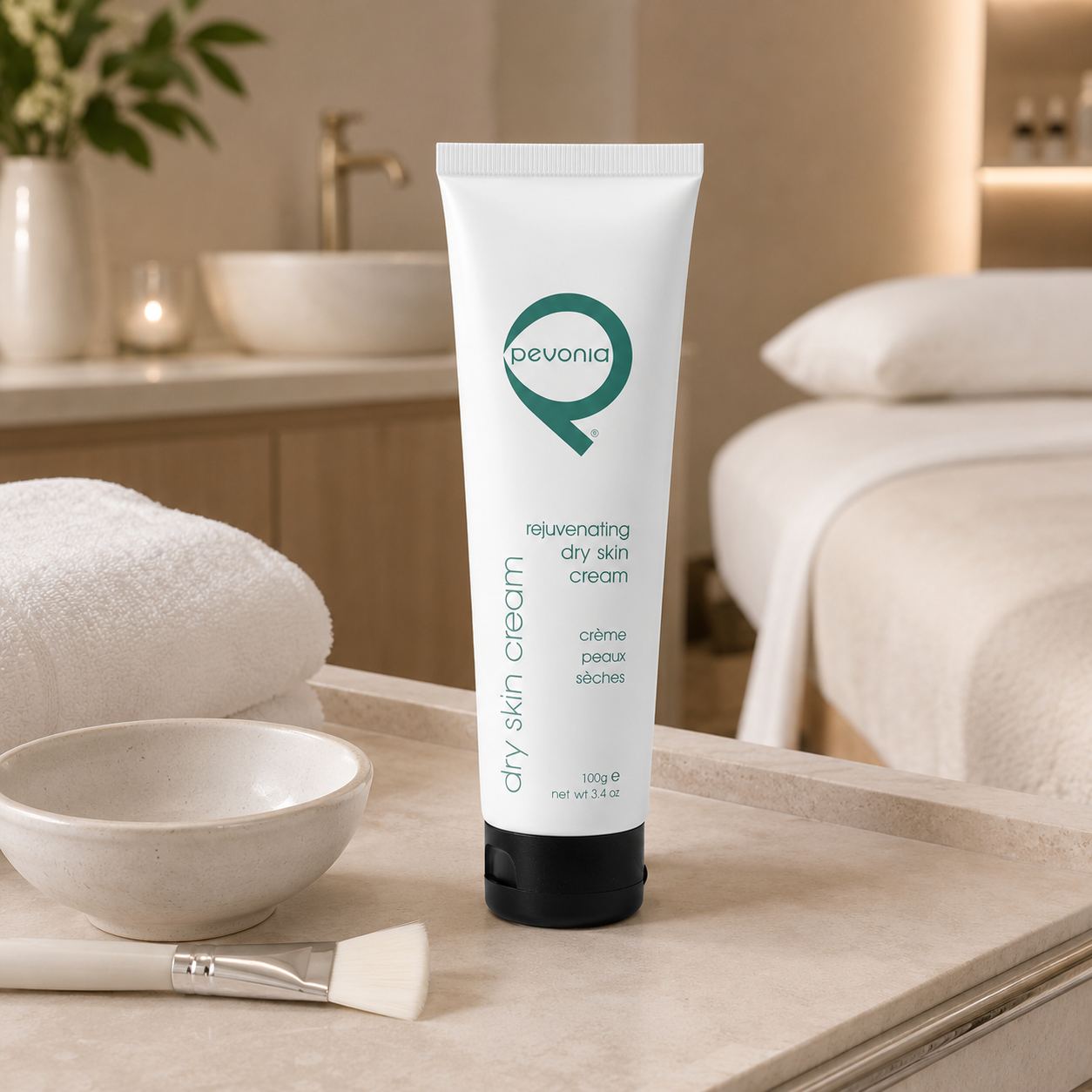 Pevonia Rejuvenating Dry Skin Cream 100g tube displayed on a therapist trolley in an upmarket day spa facial treatment room with unbranded treatment accessories.