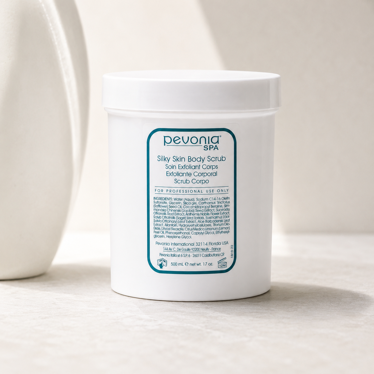 Pevonia Silky Skin Body Scrub 500ml professional jar displayed in a soft neutral spa setting.