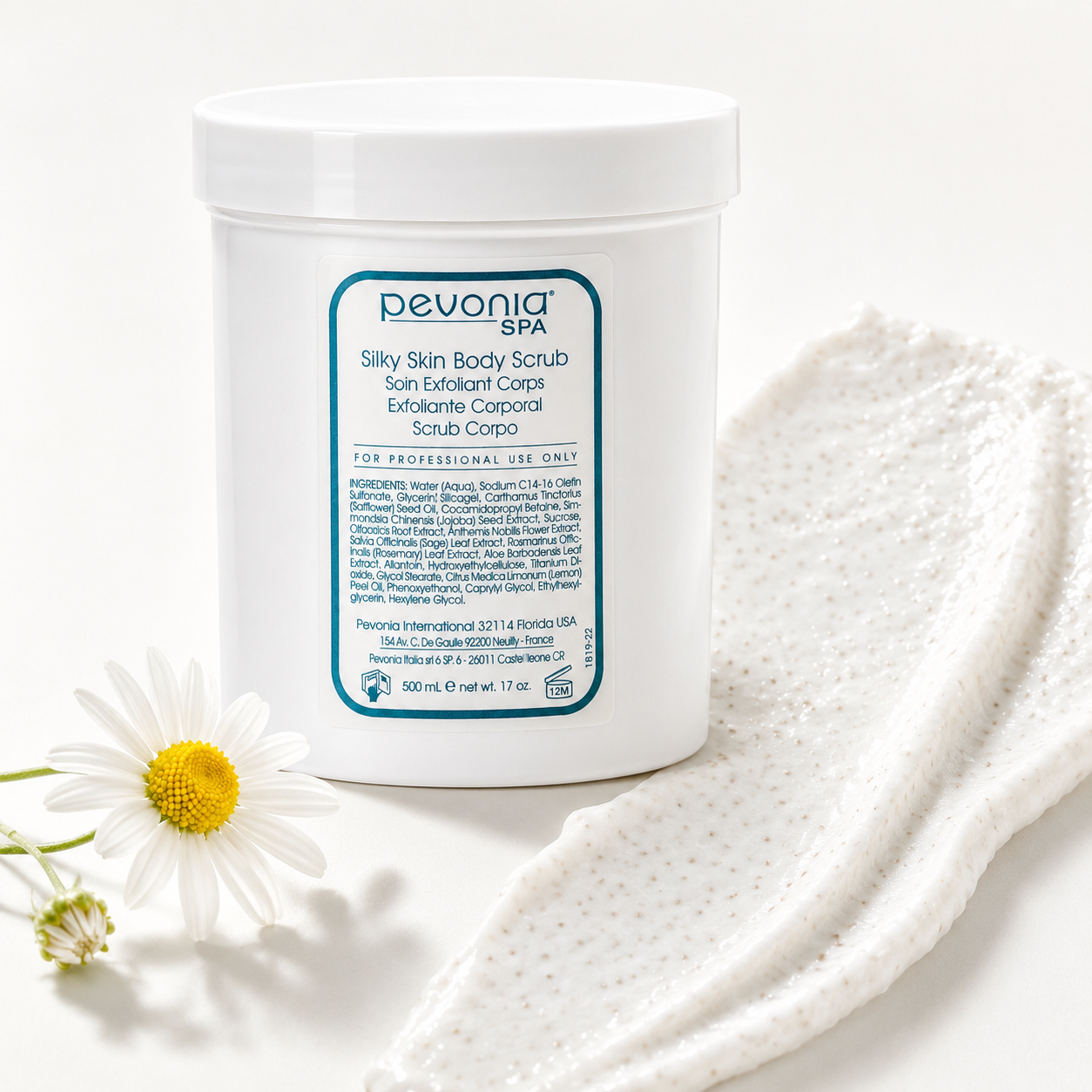Pevonia Silky Skin Body Scrub 500ml with exfoliating scrub texture and white flower on a clean studio background.
