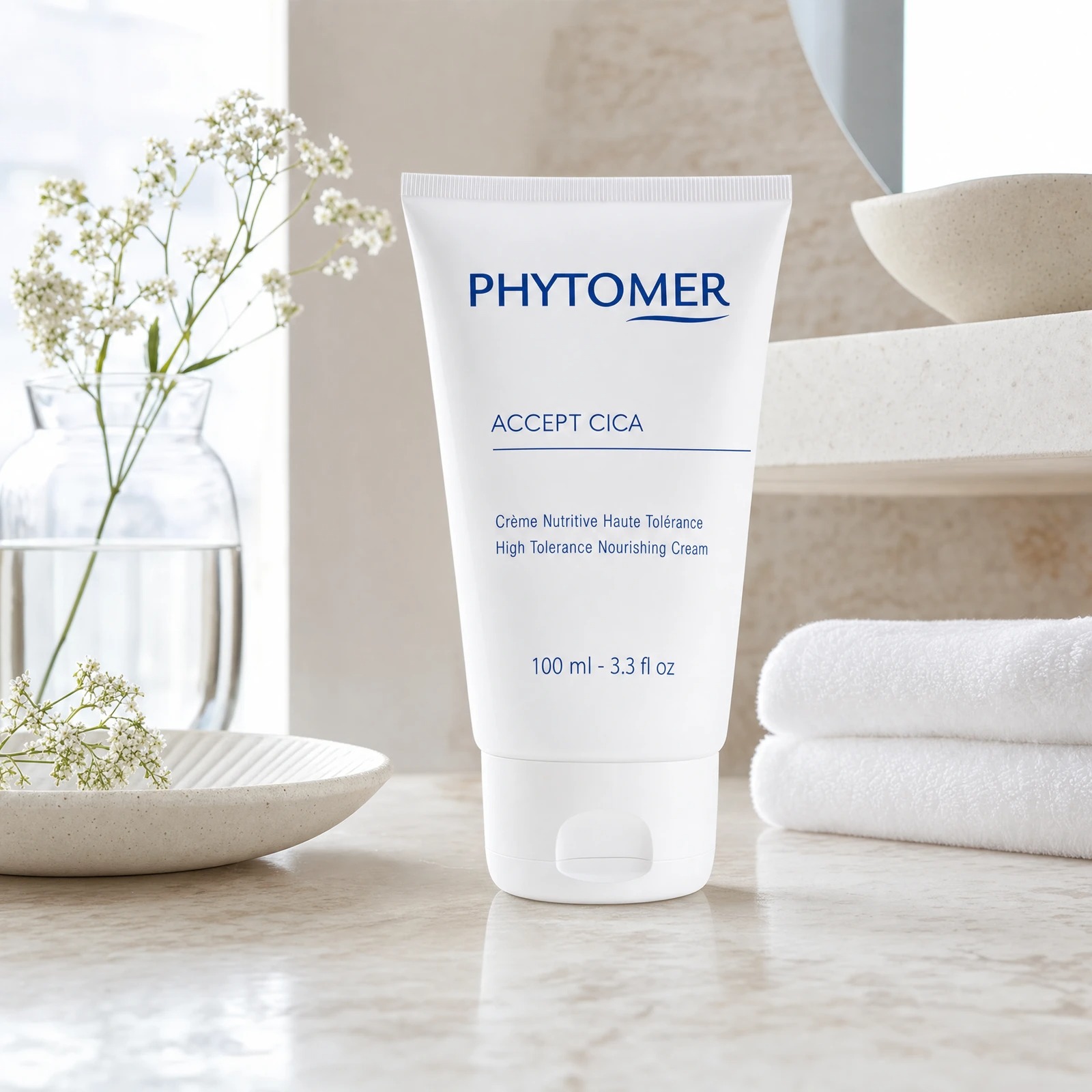 Phytomer Accept Cica High Tolerance Nourishing Cream 100ml on a marble bathroom vanity with glass vessel, white botanicals, ceramic dish and white towels, premium at-home skincare setting