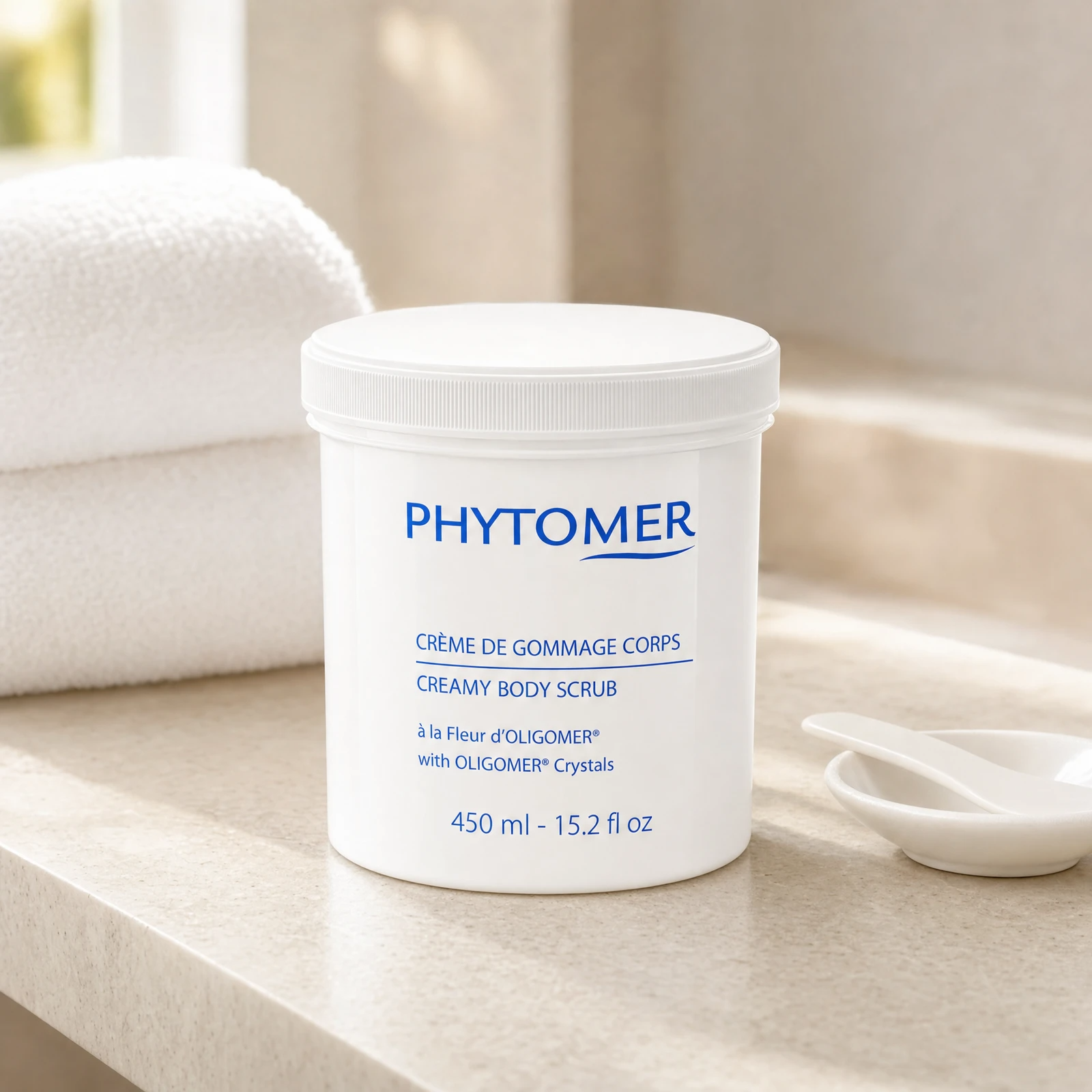 Phytomer Creamy Body Scrub with Oligomer Crystals 450ml professional tub on a premium spa body treatment stone counter with white towels and ceramic spatula