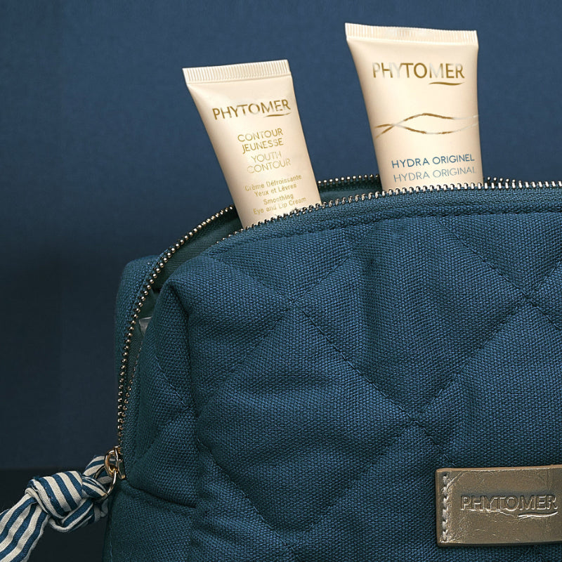 Phytomer Hydra Original and Youth Contour Eye and Lip Cream tubes in a blue cosmetics pouch.