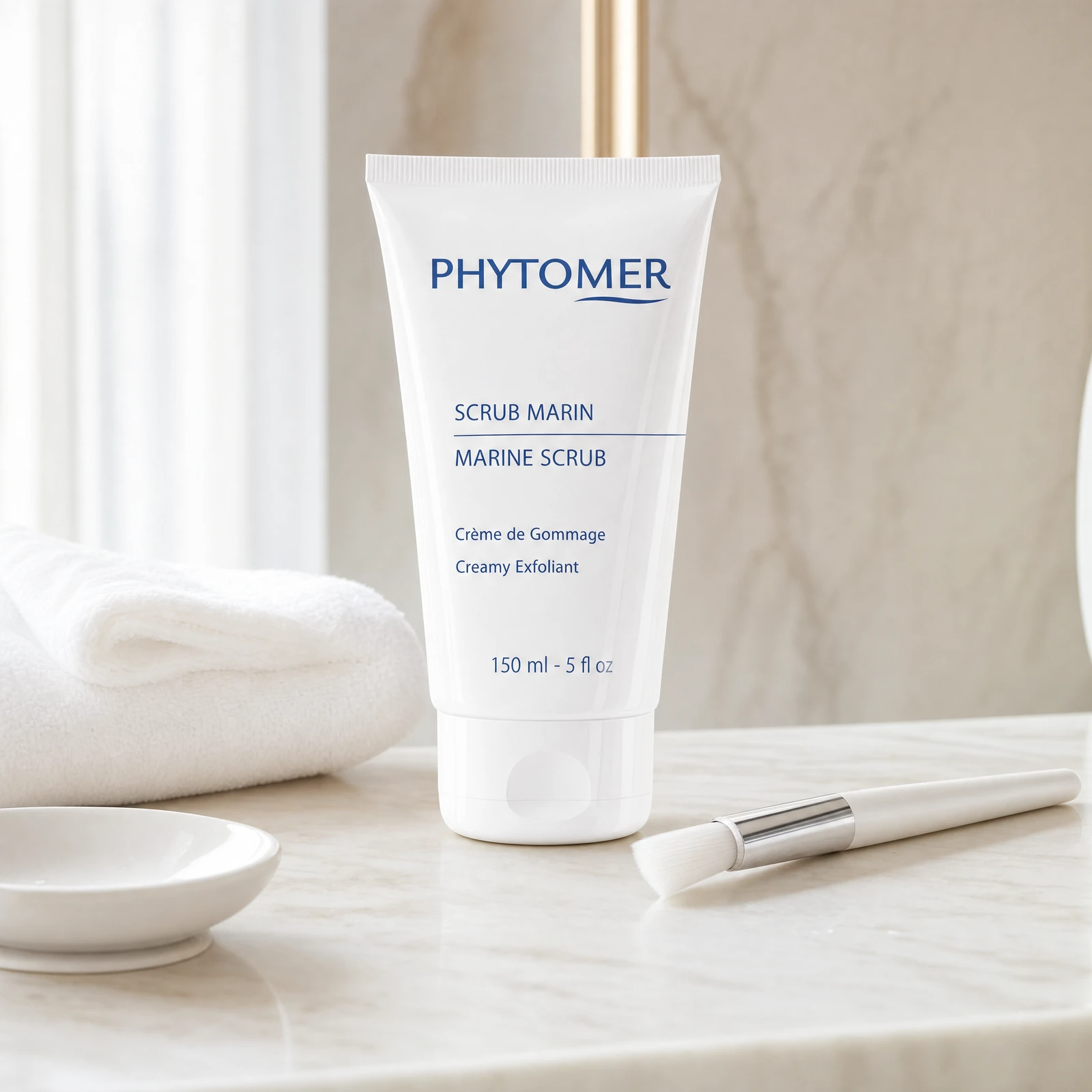 Phytomer Marine Scrub Creamy Exfoliant 150ml professional tube on a premium beauty clinic marble counter with white spa towel, ceramic dish and facial brush