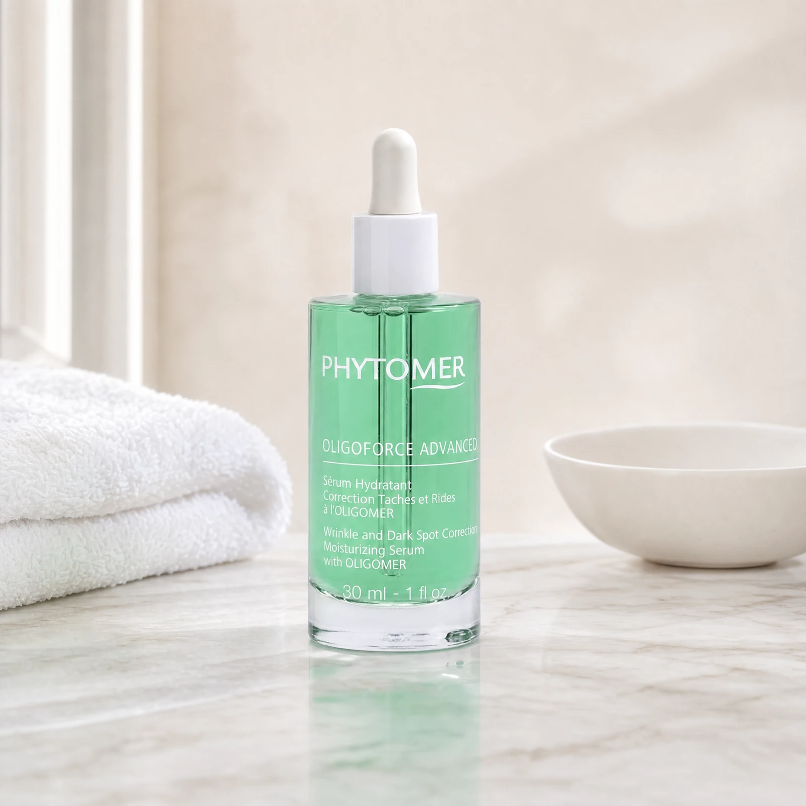Phytomer Oligoforce Advanced Moisturising Serum 30ml green glass dropper bottle on a premium beauty clinic marble counter with white spa towels and ceramic dish