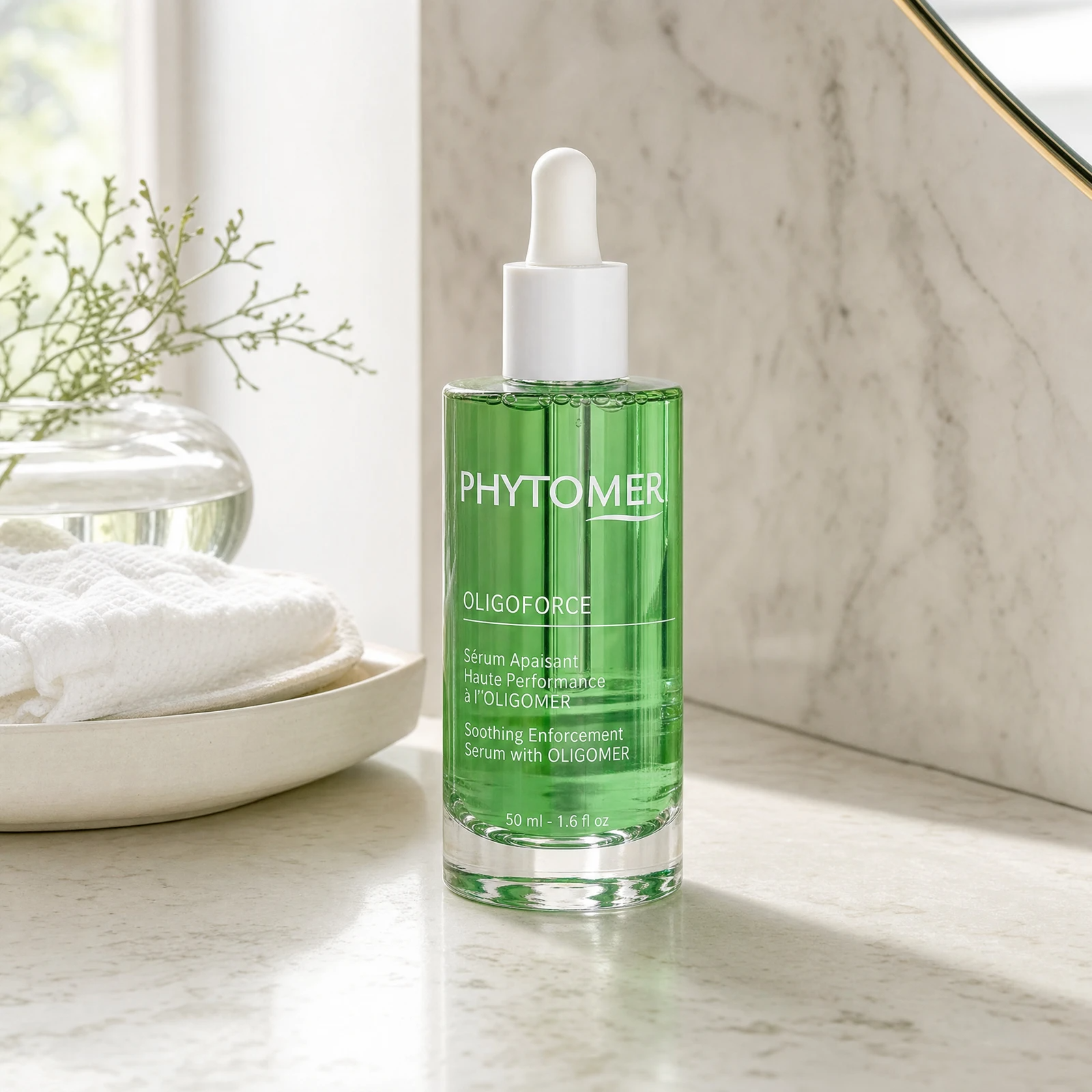 Phytomer Oligoforce Soothing Enforcement Serum with OLIGOMER 50ml on a marble bathroom counter with botanical in glass vessel, white towels and ceramic tray, premium at-home skincare setting