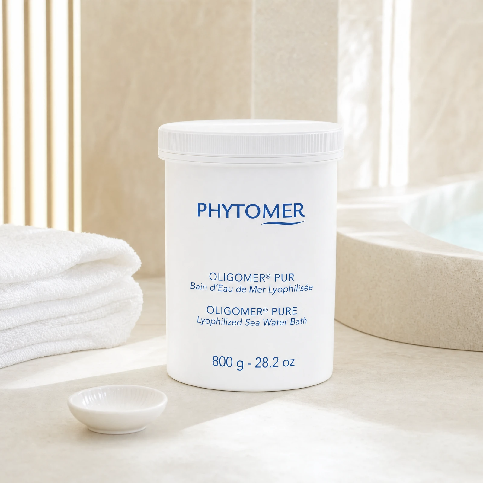 Phytomer Oligomer Pure Lyophilized Sea Water Bath 800g professional tub on a premium spa balneotherapy treatment stone counter with white towels and ceramic dish