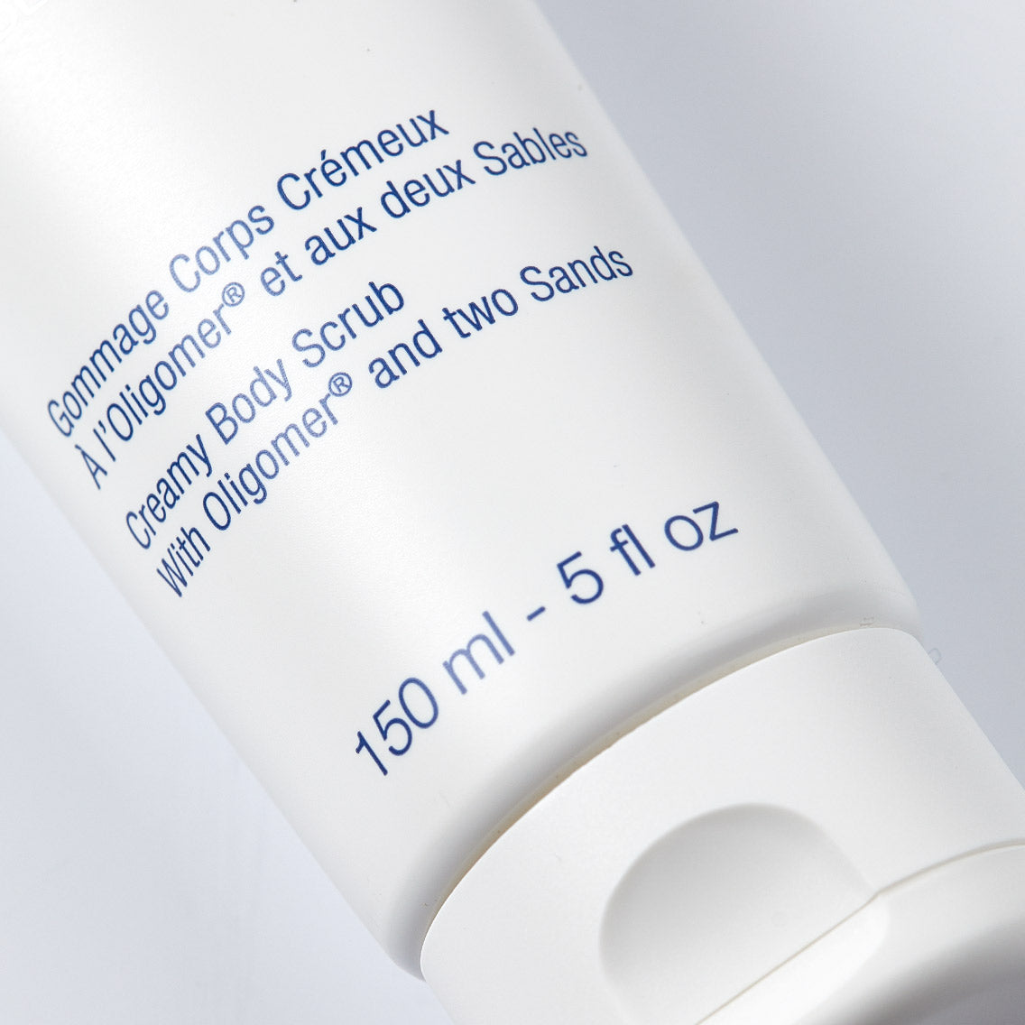 Body scrub container with blue text on a white background