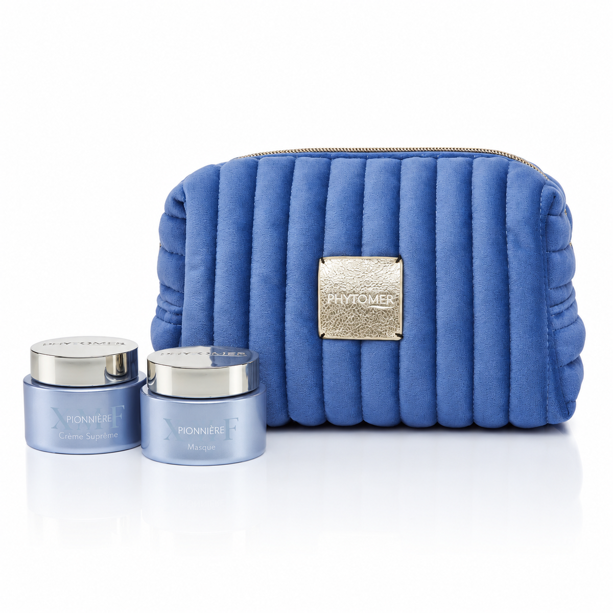 Phytomer Pionnière XMF Youth and Glow Supreme Cream and Exfoliating Mask-to-Oil with a blue cosmetics pouch on white.