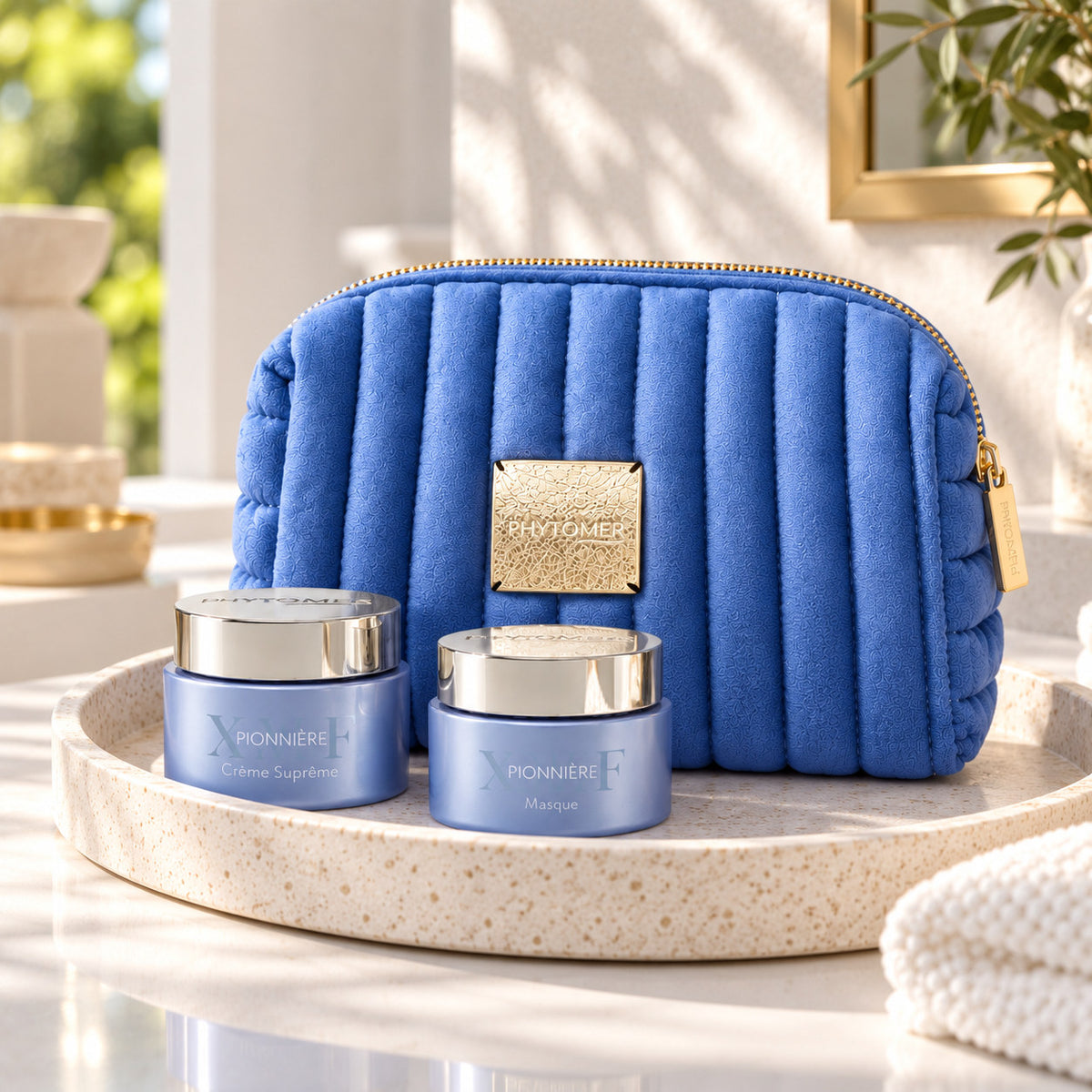 PHYTOMER Pionnière XMF Ritual Gift Set with blue cosmetics pouch and two skincare jars on a spa tray.