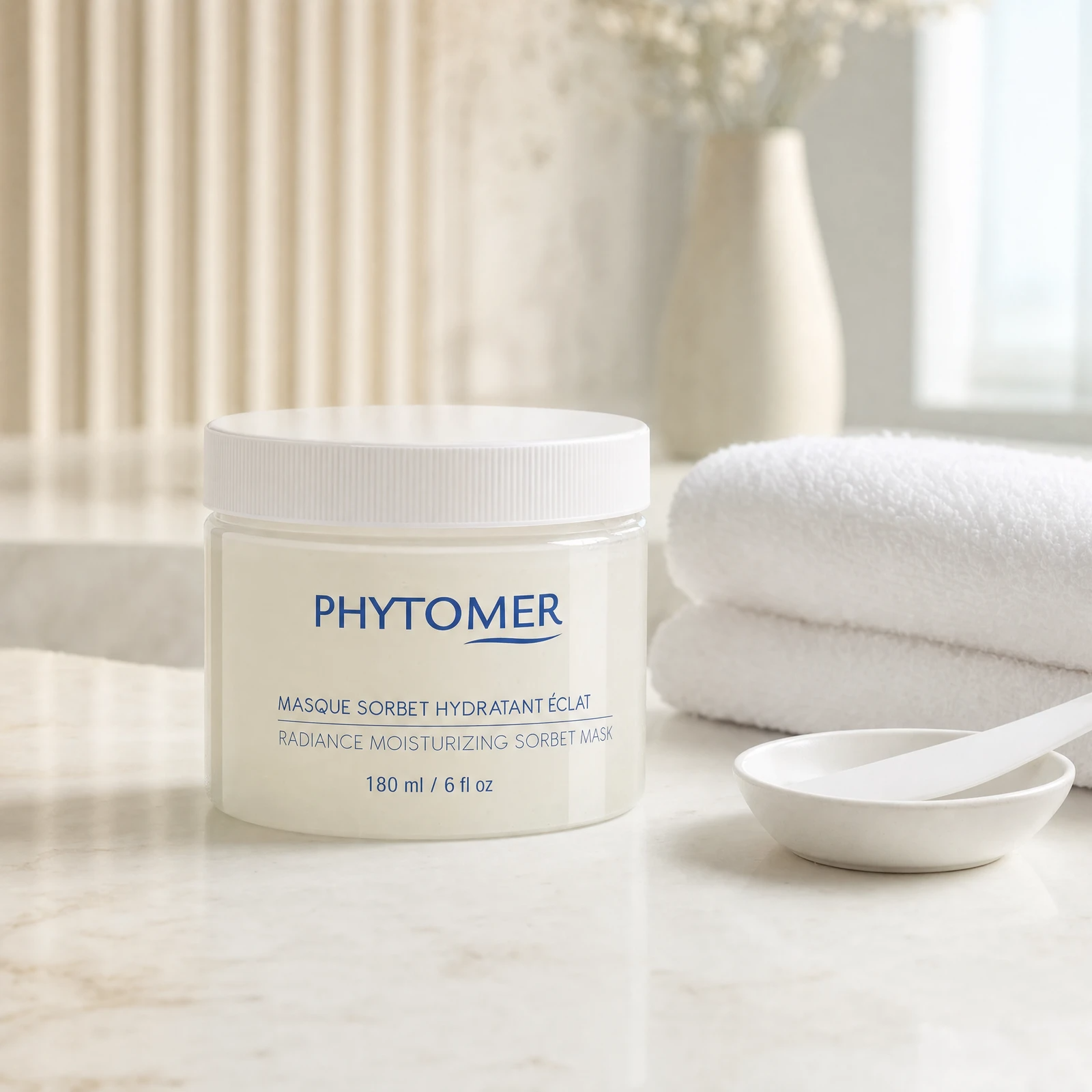 Phytomer Radiance Moisturizing Sorbet Mask 180ml frosted jar on a premium beauty clinic marble counter with white spa towels and ceramic spatula dish