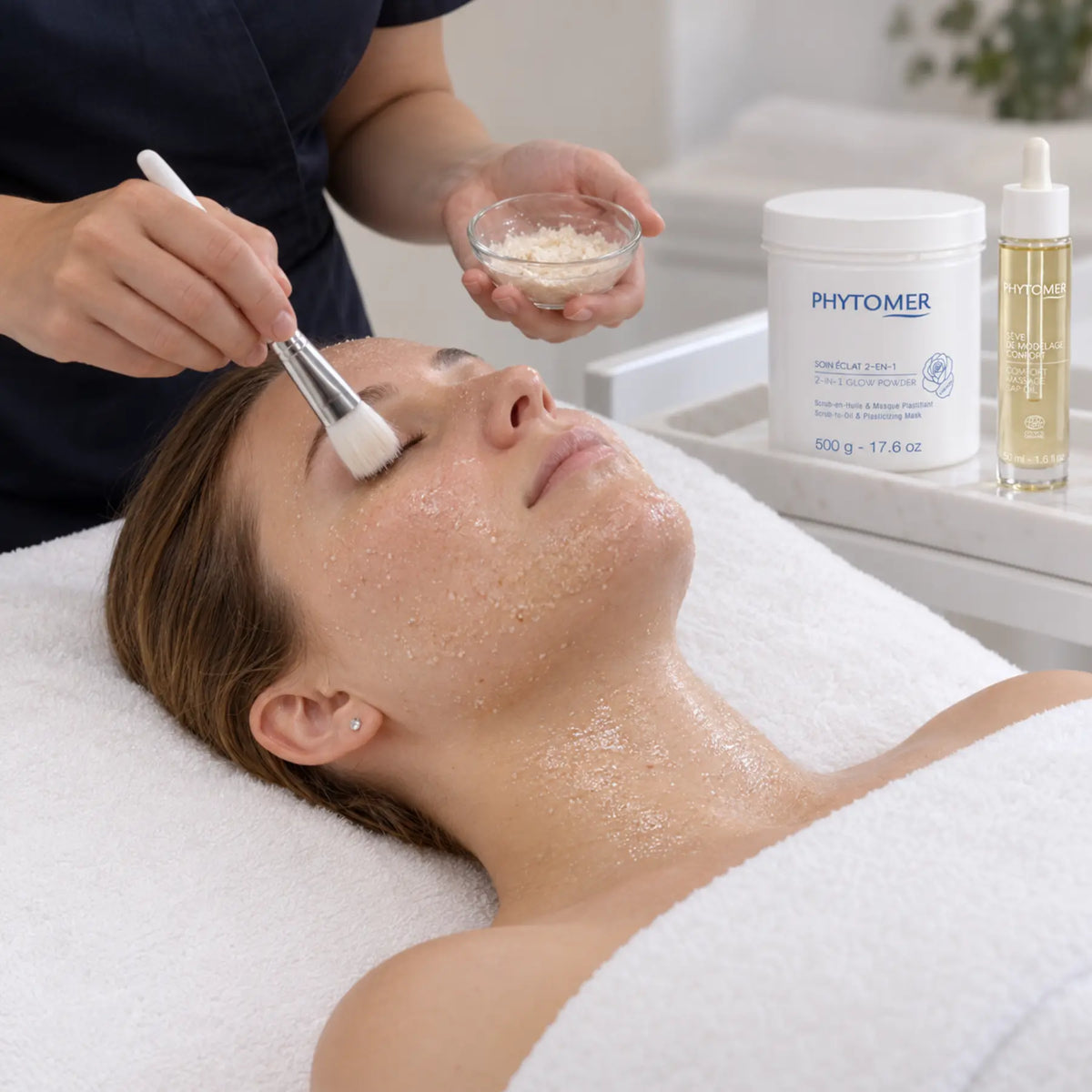 Therapist applying the PHYTOMER Rosée Glow scrub-to-oil exfoliation to the face and neck.