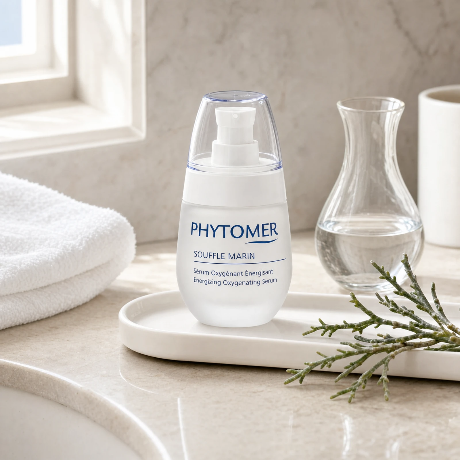 Phytomer Souffle Marin Energizing Oxygenating Serum 30ml on a marble bathroom vanity with sea samphire, glass vessel, white towels and ceramic tray, premium at-home skincare setting