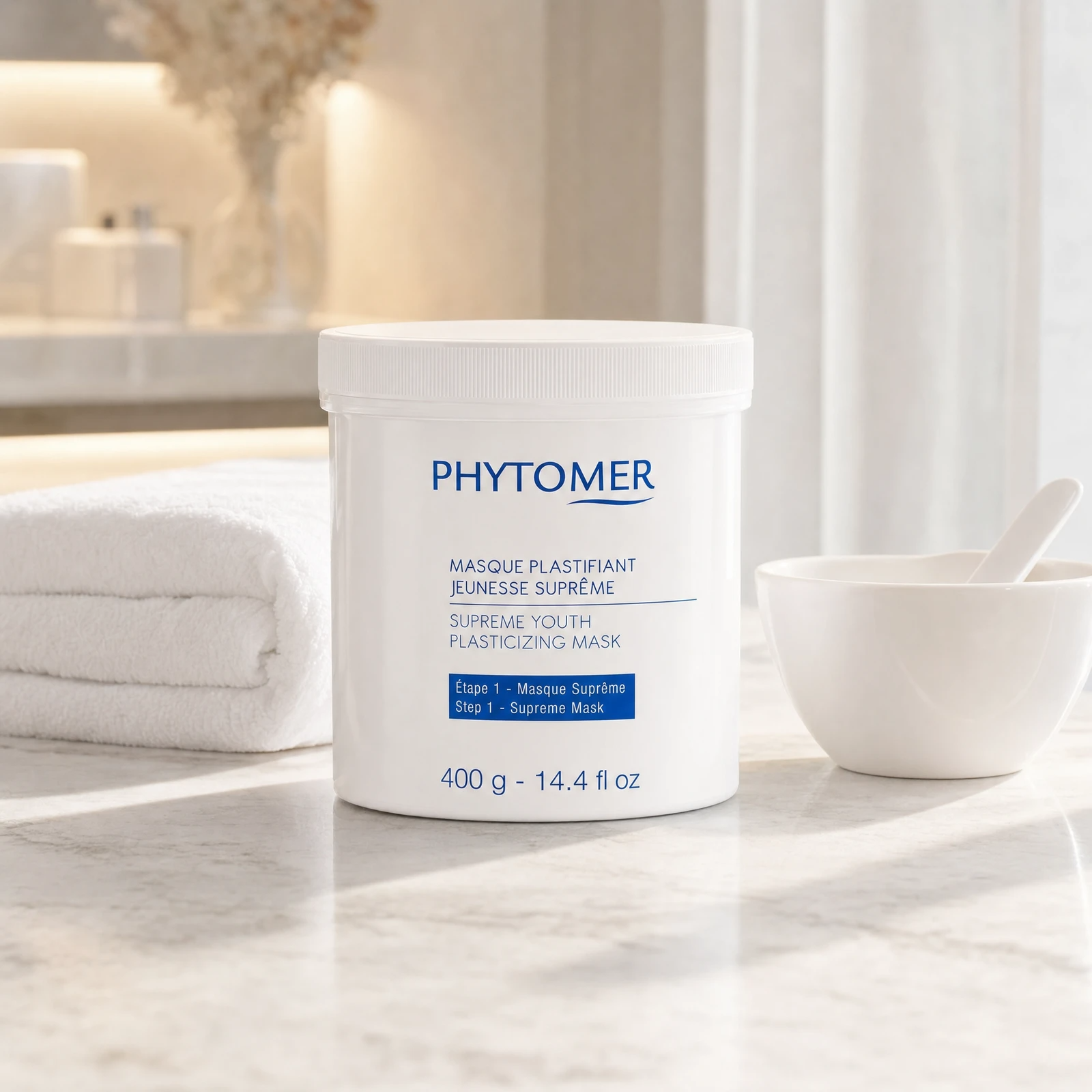 Phytomer Supreme Youth Plasticizing Mask 400g professional tub on a premium beauty clinic marble counter with white spa towels and ceramic mixing bowl