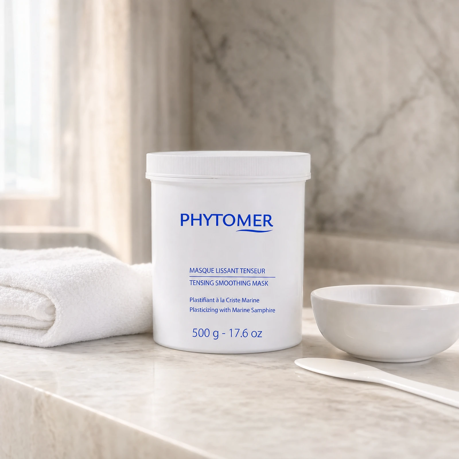 Phytomer Tensing Smoothing Mask 500g professional tub on a premium beauty clinic marble counter with white spa towels, mixing bowl and spatula