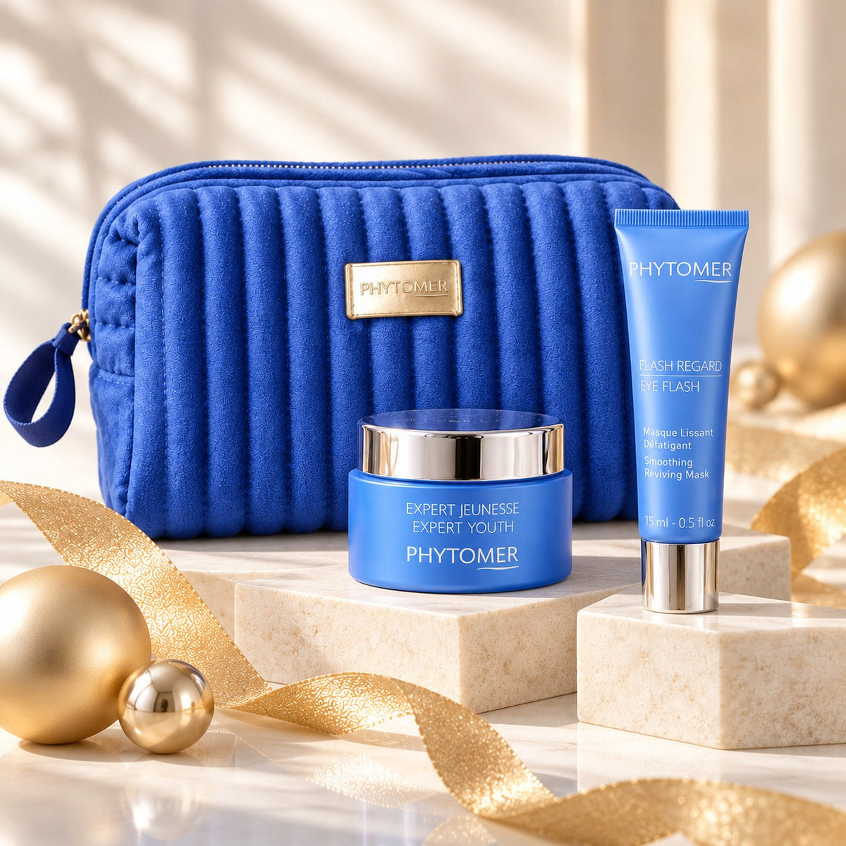 PHYTOMER Expert Youth cream and Eye Flash displayed on elegant platforms beside blue gift pouch