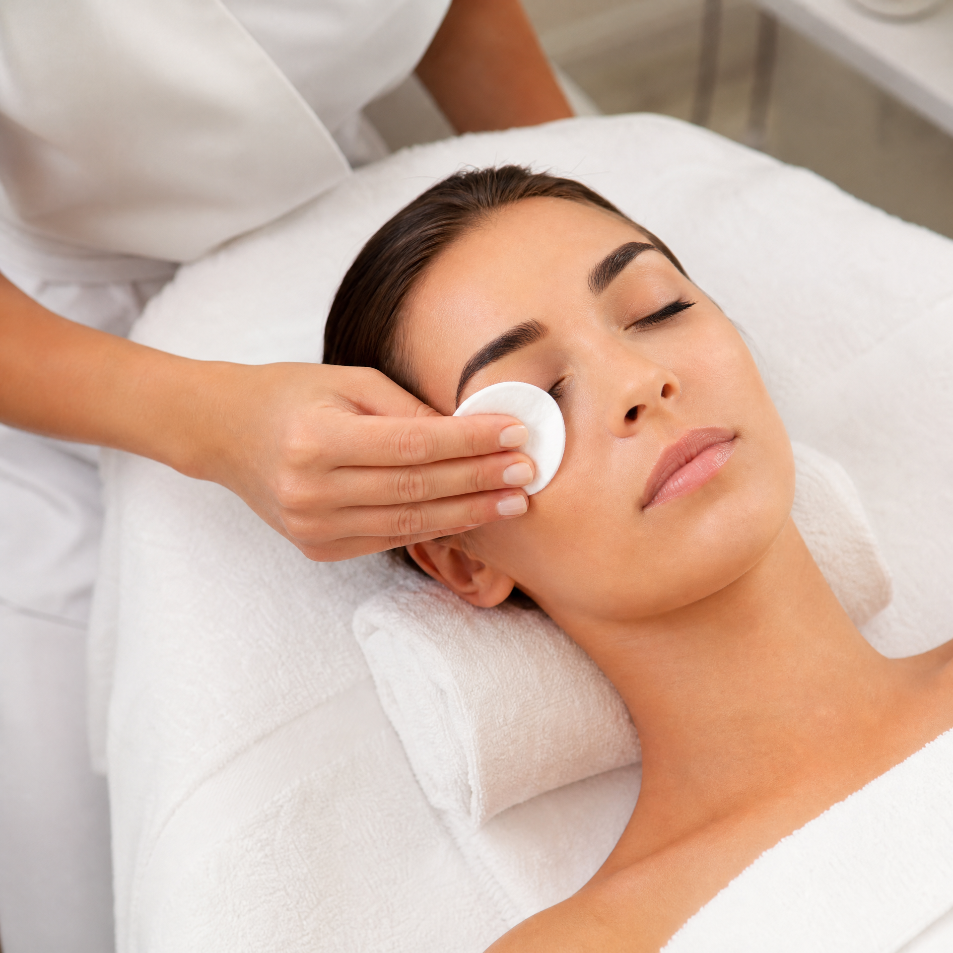 Therapist removing eye make-up with a moistened cotton pad during Pevonia Stem Cells Phyto-Elite Freeze-Dried facial treatment